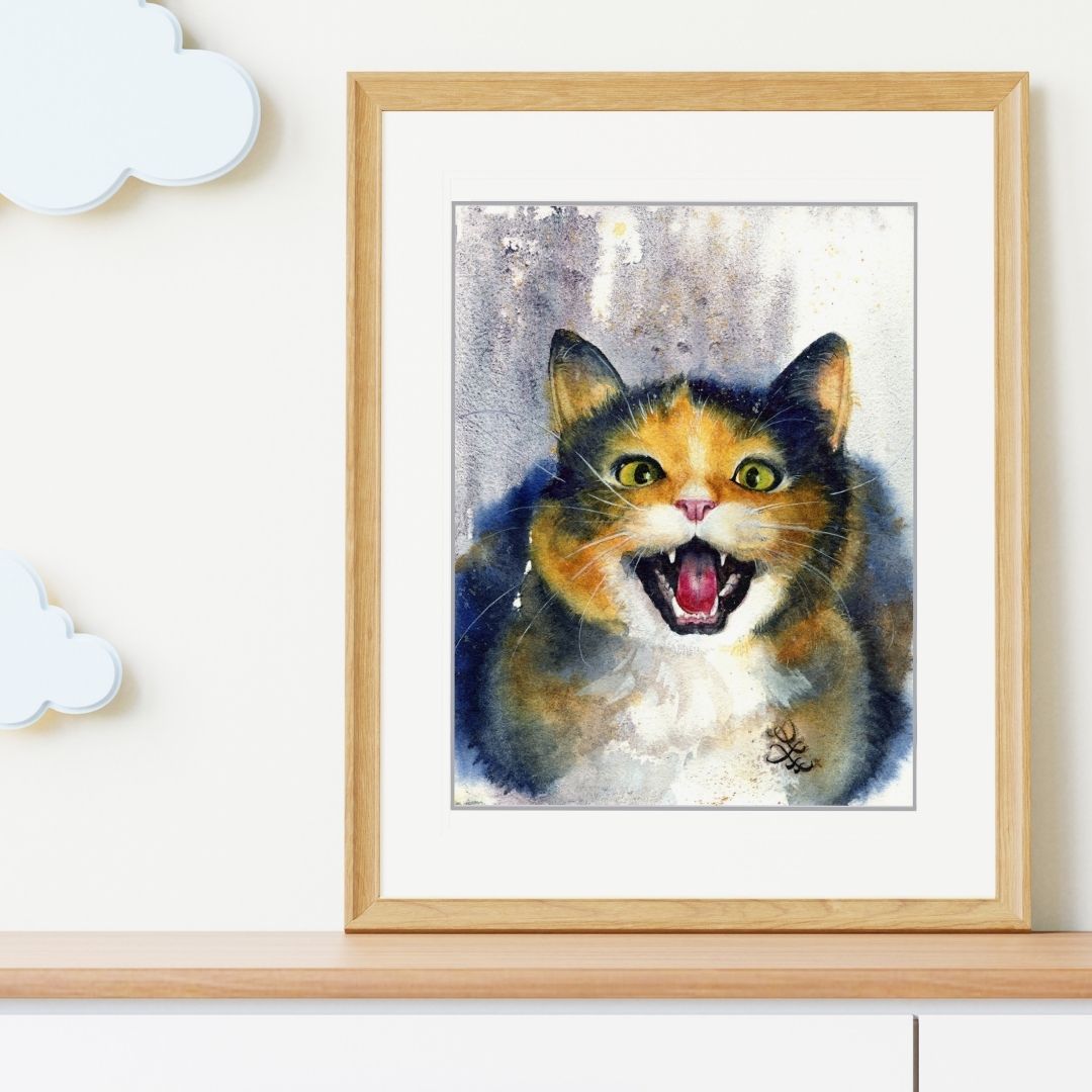 Framed painting of a calico cat with a surprised expression on a white wall. Black Cat portrait Watercolor painting by Sophie Xie Dream In Watercolor. This stunning painting is available as a print on my website, http://www.dreaminwatercolor.com