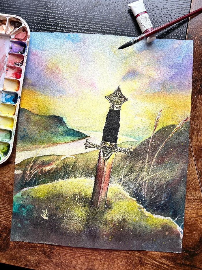The artwork titled "Legend" portrays a mesmerizing medieval scene, where a magnificent sword is firmly embedded in a weathered stone, symbolizing the strength and destiny of a future ruler. The sword, gleaming in the fading light, rises boldly on a windswept hill, its blade catching the last rays of sunlight. Below, the kingdom stretches out, bathed in golden hues as the sun dips below the horizon, casting a warm glow over the land, hinting at the legend waiting to be fulfilled.