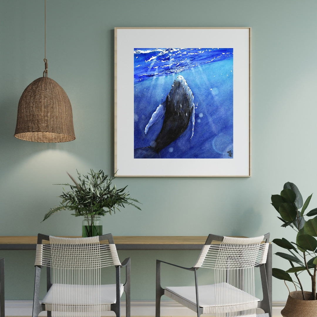 The artwork titled "Whale" vividly illustrates a majestic whale gracefully interacting with the shimmering light that dances across the ocean's surface. The waves gently ripple around it, enhancing the serene and magical atmosphere of this aquatic moment.